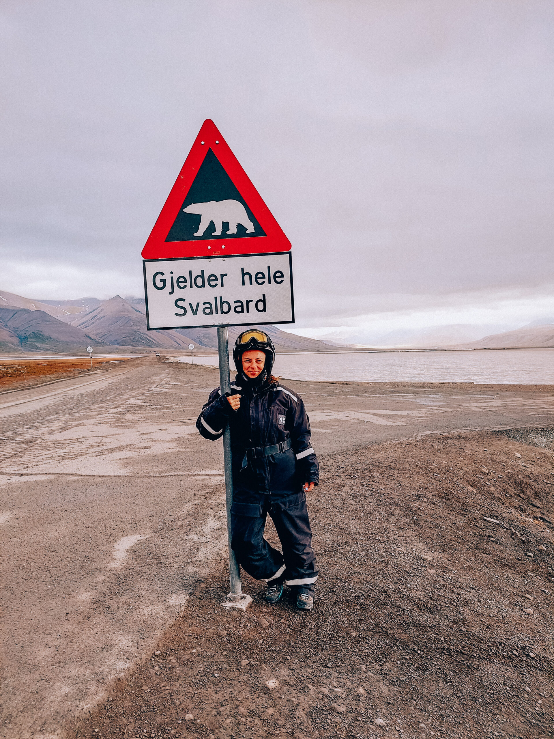 Davanti al cartello che avvisa della presenza di orsi polari in tutta l'area delle Svalbard.