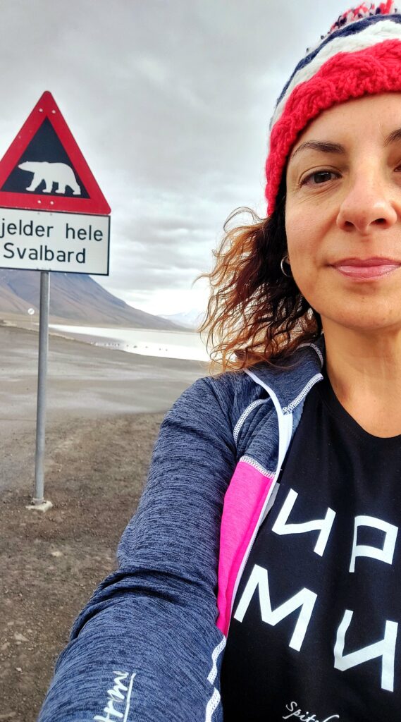 Io davanti ad un cartello che avverte del pericolo orsi alle Isole Svalbard