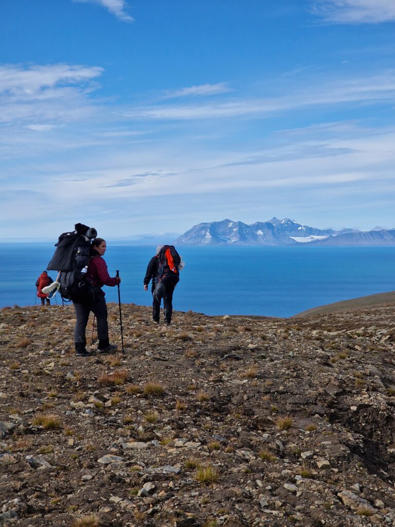 Persone che camminano e sullo sfondo il mare e le montagne