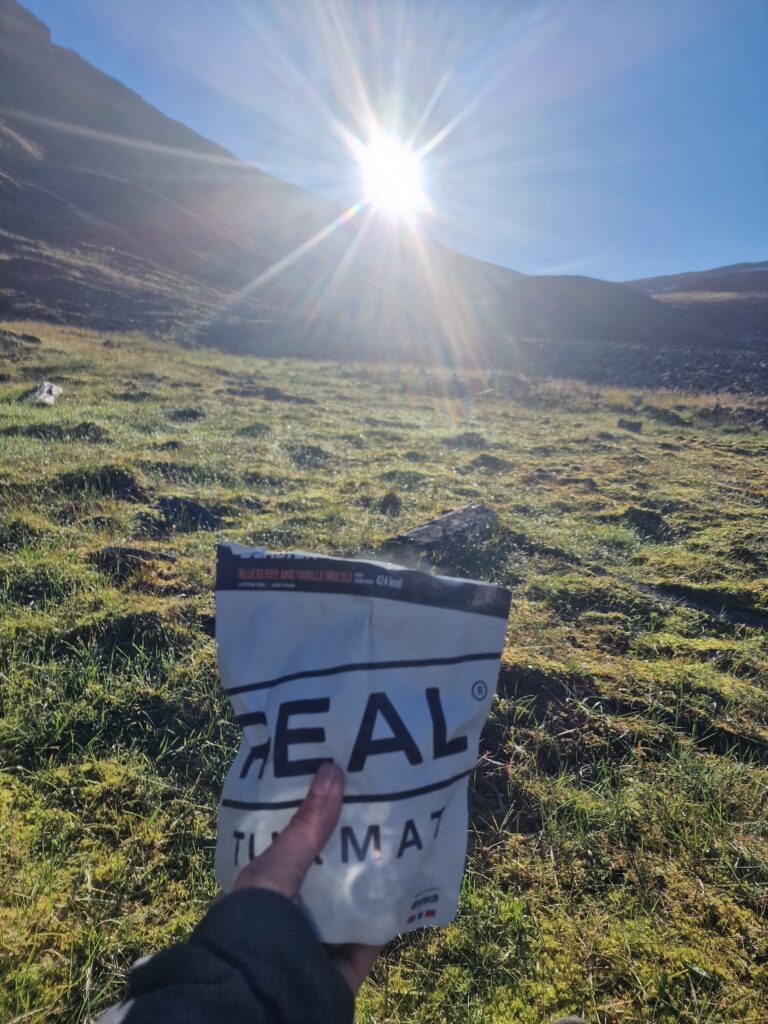 Prato, cielo blu e una busta con scritto REAL in primo piano